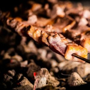 Close-up of sizzling kebabs grilling on skewers over hot coals. Perfect for barbecue enthusiasts.